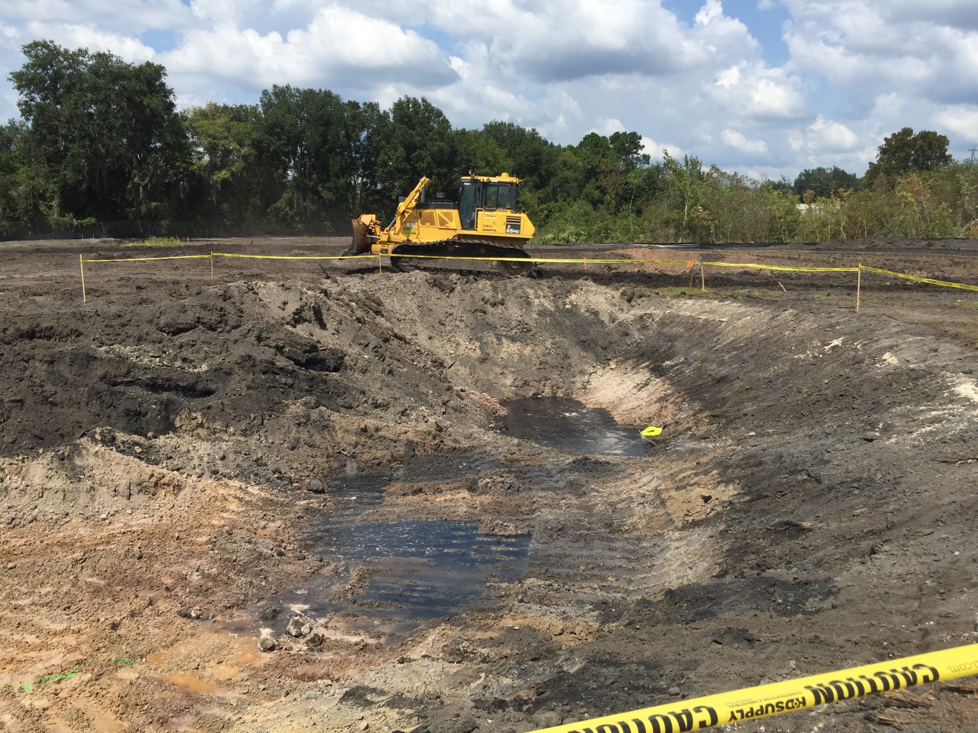 photo of an excavation area with a bulldozer in the background